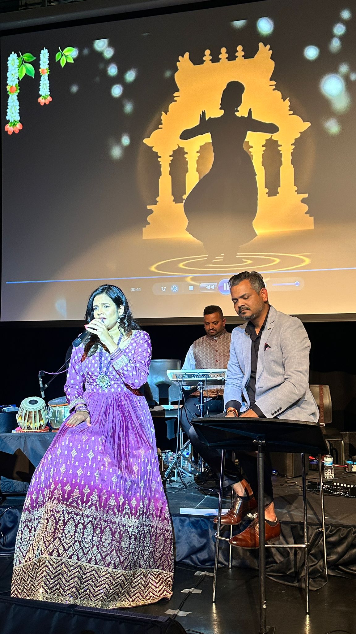 Singer performing on stage with keyboard player